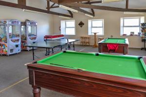 a room with two pool tables and arcade games at Finest Retreats - Toblerone Lodge in Callington