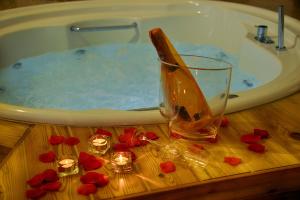 a bath tub with a glass of wine and red roses at Suite Grotta della luna - Romantic Luxury Jacuzzi in Ostuni