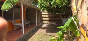 a porch of a house with two chairs on it at Premium Villa, Maison du Manguier in Les Anses-dʼArlets