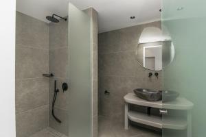 a bathroom with a shower and a sink and a mirror at Villa Leuki in Adamantas