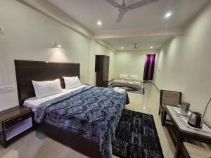 a hotel room with a bed and a desk at Little Tibet Mcleodganj in Dharmsāla
