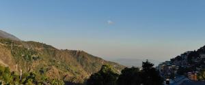 a view of a mountain with houses on it at Little Tibet Mcleodganj in Dharmsāla +5 photos