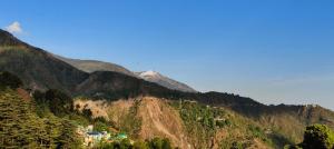 a view of a mountain with a town on it at Little Tibet Mcleodganj in Dharmsāla