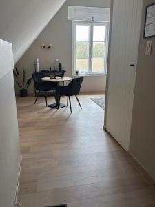 a living room with a table and chairs and a window at Maison Malo in As