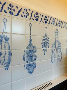 a tiled wall with blue and white dishes on it at Thatched Cottage Near Dronningmølle Beach in Dronningmølle