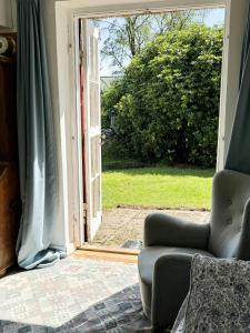 an open door with a chair in a living room at Thatched Cottage Near Dronningmølle Beach in Dronningmølle +21 photos