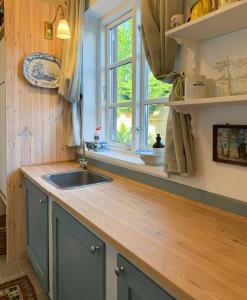 a kitchen with a sink and a window at Thatched Cottage Near Dronningmølle Beach in Dronningmølle