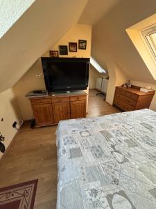 a bedroom with a flat screen tv and a bed at Ferienwohnung Hocke in Wulfsen