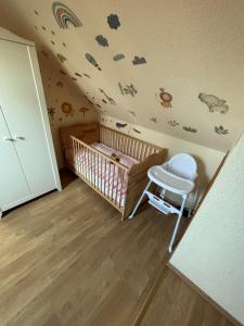 a baby room with a crib and a ceiling with stickers at Ferienwohnung Hocke in Wulfsen