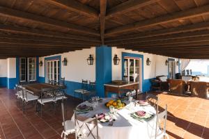 a dining room with tables and chairs and blue walls at Charming Farm House With Pool in Ferreira do Alentejo