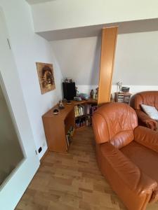 a living room with a leather couch and a television at Ferienwohnung Hocke in Wulfsen