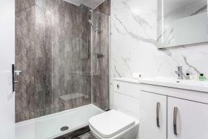 a bathroom with a shower and a toilet and a sink at Main Street View - Donnini Apartments in Prestwick