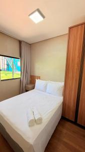 a bedroom with a bed with two slippers on it at Chalés - Aquabeat in Sao Jose da Lapa
