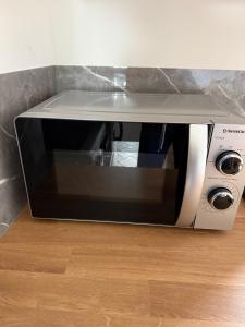 a microwave oven sitting on top of a wooden floor at JustInRent Family Szpitalna 4D-3 in Legnica +14 photos
