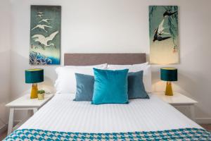 a bedroom with a large bed with blue pillows at Walker Suite No53 - Donnini Apartments in Kilmarnock