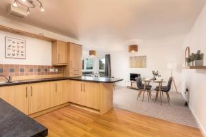 a kitchen with wooden cabinets and a dining room at Walker Suite No53 - Donnini Apartments in Kilmarnock