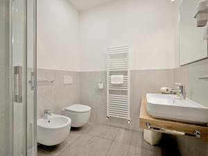 a bathroom with a sink and a toilet at Pegaso Civico2 in Garda +48 photos