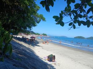 a group of people on a beach with the ocean at Pousada Coutinho in Paraty