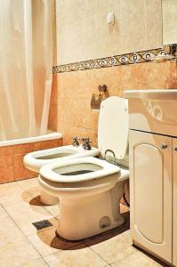 a bathroom with a white toilet and a sink at Ortegal Urban Suites in Mar del Plata +23 photos