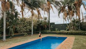 a woman in a bikini standing in a swimming pool at Oregon House in Riebeek-Wes