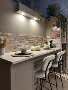 a kitchen with a counter with two chairs and a table at BREATH47SPA - Private Spa Suite White Jacuzzi & Sauna in Marbella in Marbella
