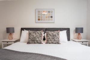 a bedroom with a large white bed with two lamps at Walker Suite No73 - Donnini Apartments in Kilmarnock
