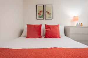 a white bed with red pillows in a bedroom at Walker Suite No73 - Donnini Apartments in Kilmarnock +2 photos