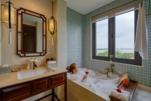 a bathroom with a dog laying in a bath tub at Savvy in Hoi An - The Essence of Refined Retreat in Hoi An