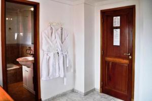 a bathroom with white clothes hanging on a wall at Ortegal Urban Suites in Mar del Plata