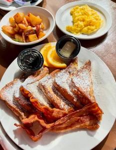 a plate of food with bacon and eggs and french fries at The Mafolie Hotel in Mafolie