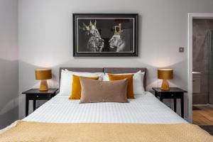 a bedroom with a bed with two lamps on tables at Seafield House - Donnini Apartments in Ayr +9 photos