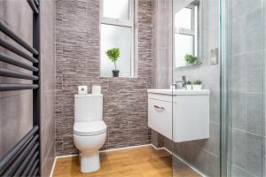 a bathroom with a toilet and a sink at Seafield House - Donnini Apartments in Ayr