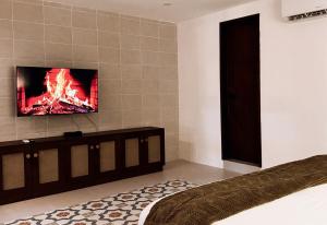 a bedroom with a tv on the wall and a bed at Casa San Martín, Campeche #2 in Campeche