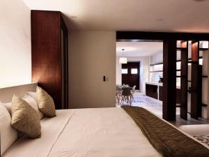 a bedroom with a large bed and a living room at Casa San Martín, Campeche #2 in Campeche
