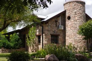 a stone house with a stone chimney at Finca La Marta - El Cortijo Wine Lodge in Capilla del Monte
