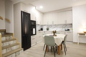 a kitchen with a table and a black refrigerator at LaJoya De La Villa in Priego de Córdoba