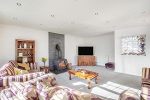 a living room with couches and a tv and a fireplace at 4 Bed in Caernarfon oc-86423 in Pen-y-groes