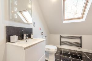 a white bathroom with a toilet and a mirror at 4 Bed in Caernarfon oc-86423 in Pen-y-groes +22 photos