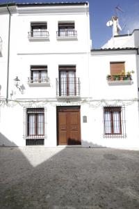 a white building with a brown door and windows at LaJoya De La Villa in Priego de Córdoba