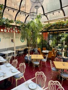 a restaurant with tables and chairs and plants at Mamy Blue Slow Living in Athens