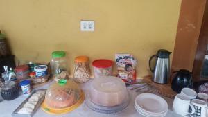 a counter top with jars and other food items at Chacara desejo do coração dois in Juquitiba