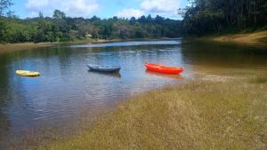 three boats sitting in the water on a river at Chacara desejo do coração dois in Juquitiba