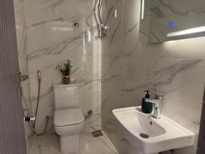 a white bathroom with a toilet and a sink at Colour holiday Zayed in Sheikh Zayed +11 photos
