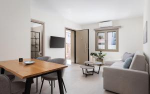 a living room with a table and a couch at Fasma Suites in Perdika