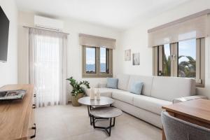 a living room with a white couch and a table at Fasma Suites in Perdika +33 photos