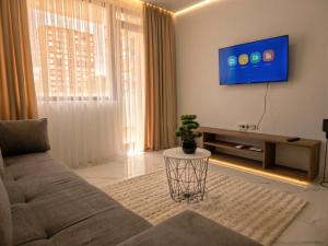 a living room with a couch and a tv at Kasibel Suites in Sandanski