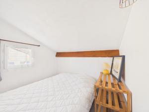 a bedroom with a white bed and a wooden shelf at Maison avec piscine à 200m de la plage in Saint-Michel-Chef-Chef +21 photos
