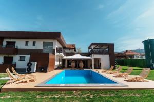 a backyard with a pool and chairs and a house at Villa Sunce in Visoko
