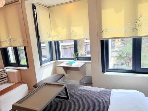 a bedroom with windows and a bed and a table at MEYS Apartment 2 in Istanbul