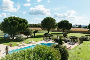 a pool in a yard with chairs and trees at Sous Les Pins in Étoile-sur-Rhône